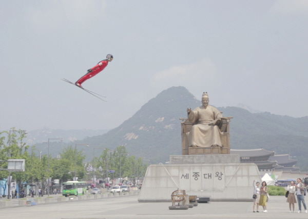 광화문에 설치된 스키점프대에서 날아오르는 스키점프 선수. <제공=문화관광부>
