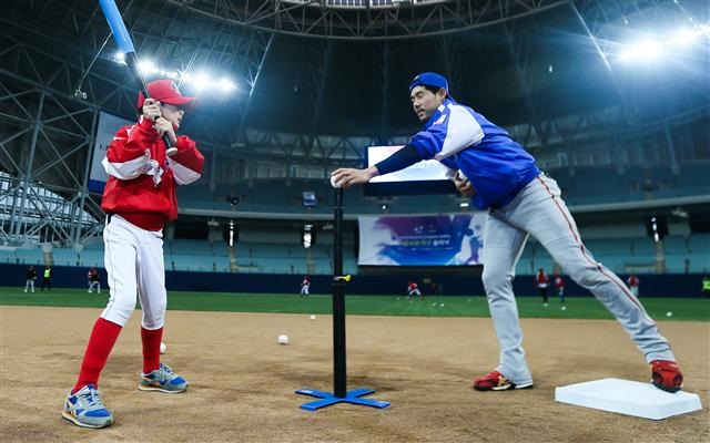 한화 이용규(오른쪽) 선수가 지난해 열린 ‘현역 프로야구 선수들과 함께하는 유소년 야구 클리닉’에 참가해 한 어린이의 타격 자세를 지도하고 있다. <출처=연합뉴스>