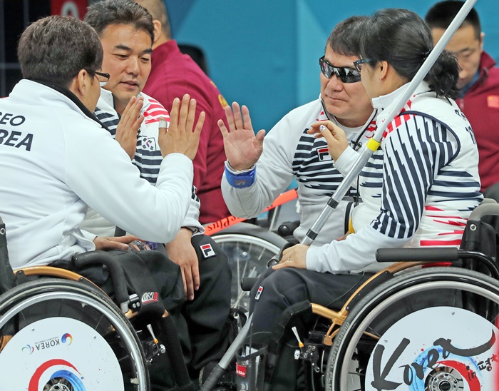 한국 휠체어컬링 대표팀 선수들이 15일 강릉컬링센터에서 열린 2018 평창동계패럴림픽 휠체어컬링 중국과 예선 마지막 경기 직전 선전을 다짐하며 하이파이브를 하고 있다. <사진=연합뉴스>