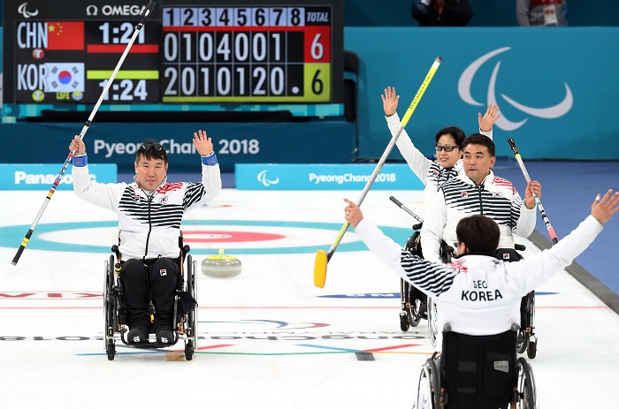 2018 평창동계패럴림픽 휠체어 컬링 예선 11차전 대한민국과 중국의 경기에서 7대6으로 승리한 한국 선수들이 손을 들어 올리며 기뻐하고 있다. <출처=연합뉴스>