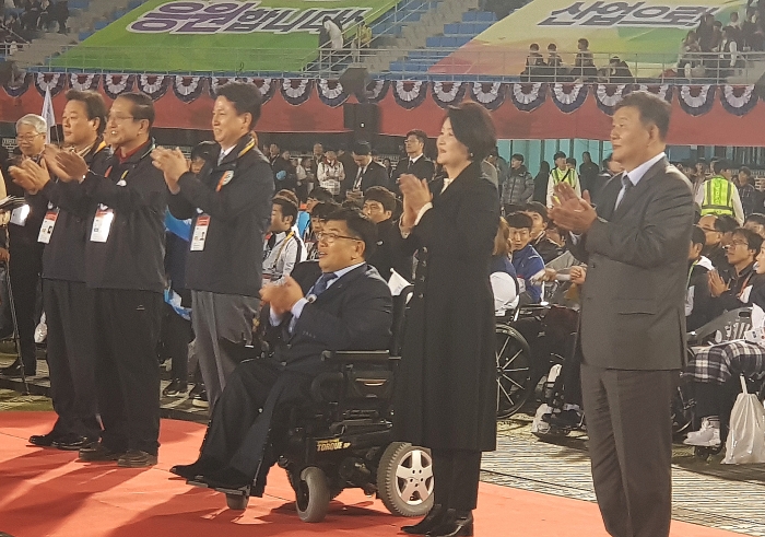 대한장애인체육회 이명호 회장(왼쪽)과 영부인 김정숙 여사가 선수들을 입장하는 선수단을 격려하고 있다.