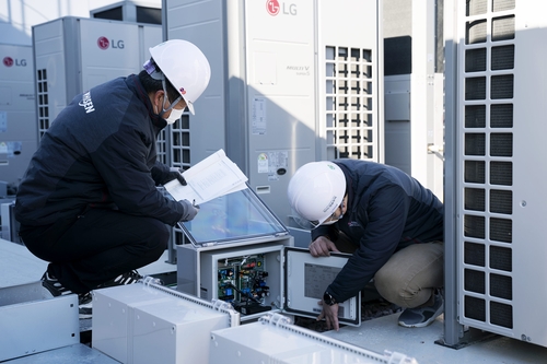 LG전자 직원들이 경상남도 김해시 진영휴게소에 설치된 하이브리드 히트펌프 시스템 에어컨을 점검하고 있다.