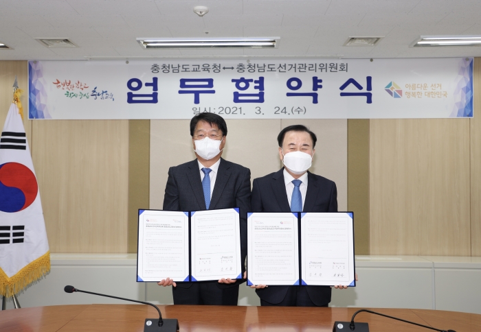 송봉섭 충남선관위 상임위원(왼쪽)과 김지철 충남교육감이 업무협약을 체결했다