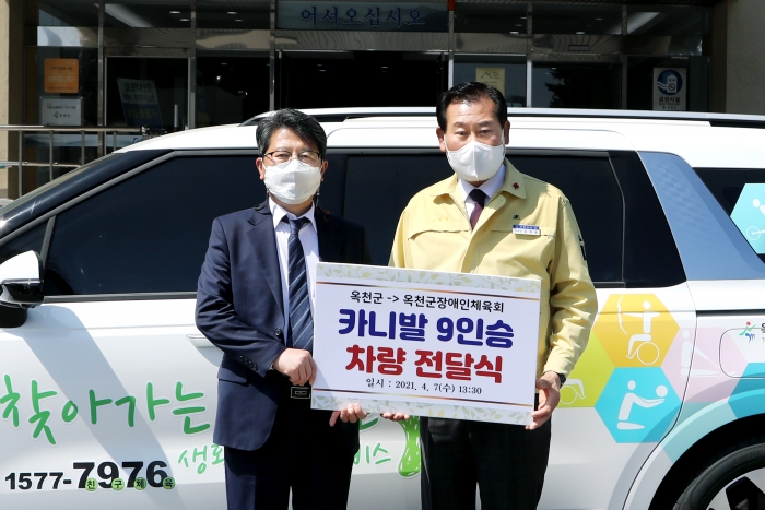 김재종 옥천군수(오른쪽)가 이상욱 옥천군장애인체육회 사무국장에게 차량을 전달하고 있다