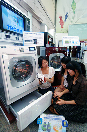 고객들이 LG전자가 2008년 출시한 드럼세탁기에 탑재된 서랍형 신발관리기를 체험하고 있다.