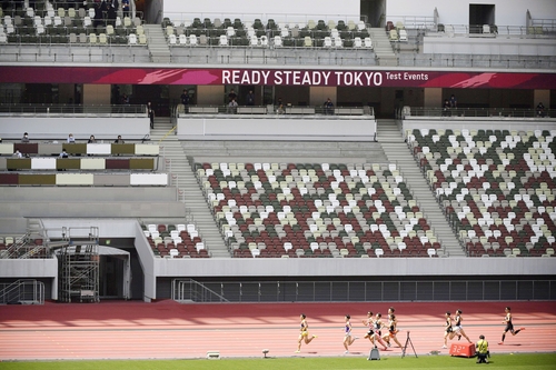 도쿄올림픽 개막을 2개월여 앞둔 지난 5월 9일 도쿄 국립경기장에서 열린 테스트 경기에서 육상 선수들이 관람객이 없는 상태에서 달리기를 하고 있다 (사진=연합뉴스)