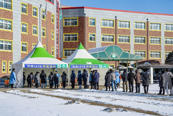 갑자기 추워진 날씨에도  시민들이 삼학초등학교 운동장에서 코로나19검사를 받기 위해 줄을 서있다.