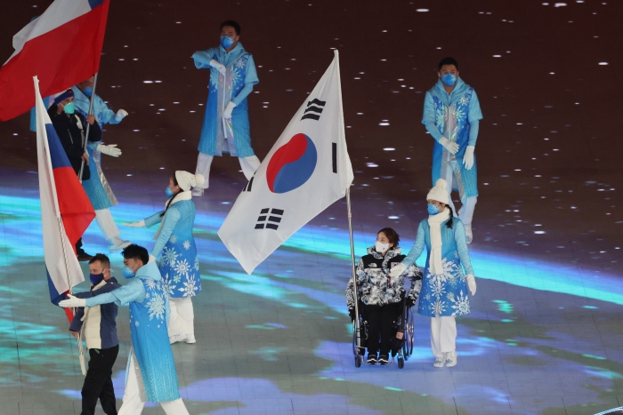 (사진=13일(한국시간) 열린 2022 베이징 동계 패럴림픽 폐회식에서 한국 대표팀 기수인 휠체어컬링 백혜진이 태극기를 들고 입장하고 있다 / 연합뉴스)