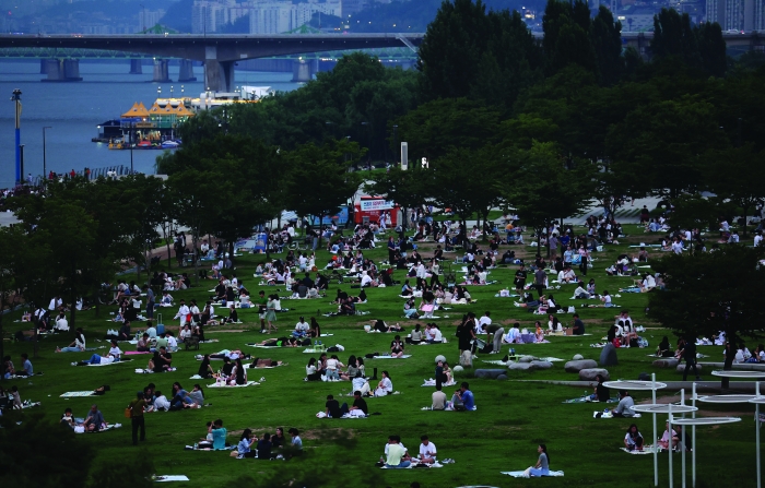 서울 여의도 한강공원을 찾은 시민들이 잔디에 앉아 열대야를 피해 휴식을 취하고 있다.