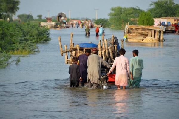 지난해 8월 파키스탄 소바트푸르 지역 주민들이 몬순 우기 홍수로 물에 잠긴 도로에서 가재도구를 싣고 이동하고 있다. 연합뉴스 제공