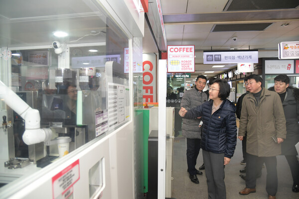 지난 24일 경기 용인시 죽전휴게소에서 오유경 식품의약품안전처장이 무인 로봇이 커피를 제조하는 것을 살펴보고 있다. (식품의약품안전처)
