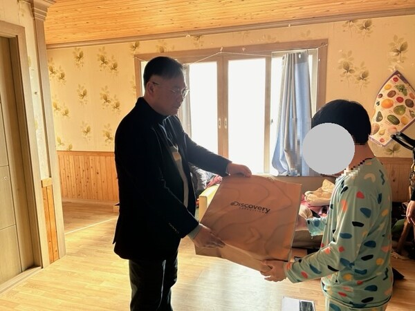 신안군 드림스타트 팀장이 아동에게 책가방을 전달하고 있다.