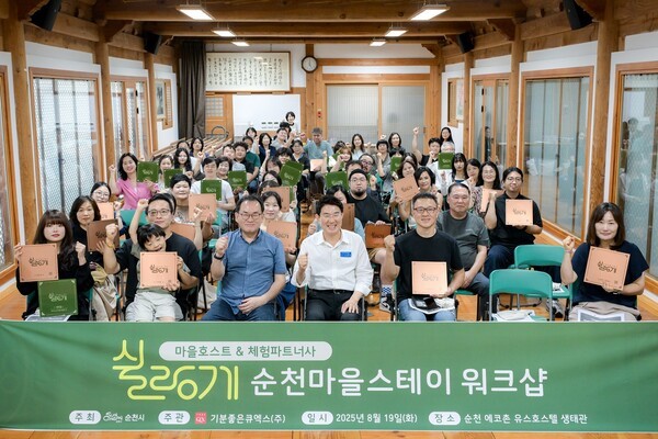 지난 8월 순천만 에코촌에서 열린 「2025 순천마을스테이 쉴랑게 워크숍」에서 노관규 순천시장을 비롯해 마을호스트·체험파트너사 관계자들이 단체사진을 촬영하고 있다[사진=순천시 제공]